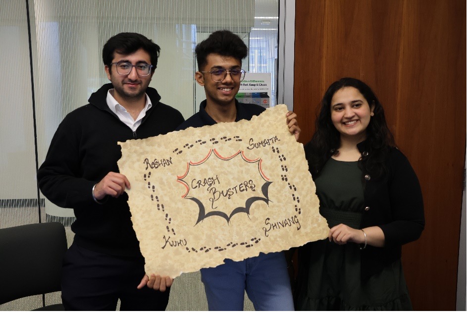 MBAN students Shivang Gulati, Roshan Shetty and Kuhu Puranik holding up their team’s sign.