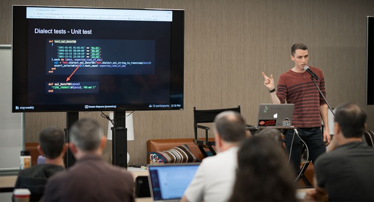 Image of Gustav presenting in front of a room full of people