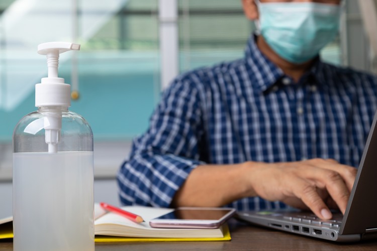 Laptop user wearing a mask.