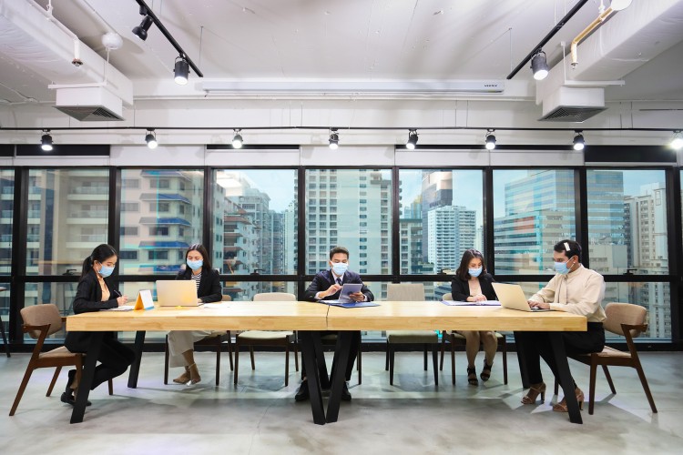 A boardroom with people wearing masks.