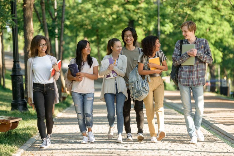 Happy young students walking outdoors