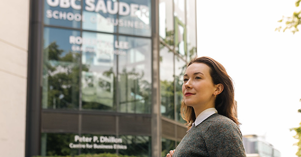 A student stands outside of the Henry Angus Tower