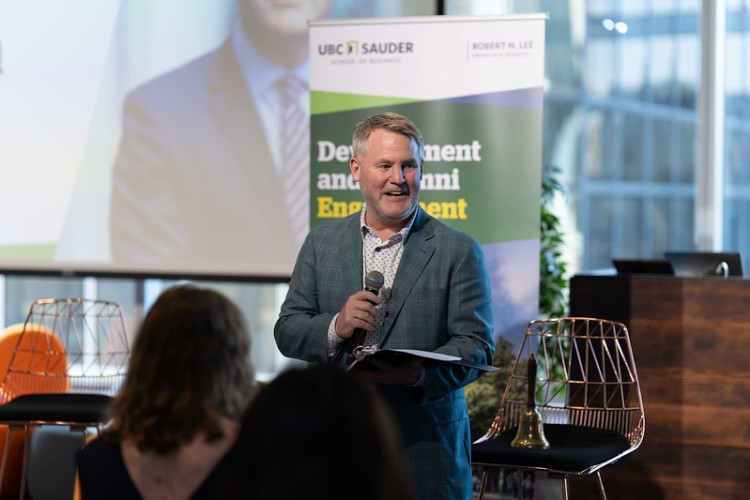 UBC Sauder Dean Darren Dahl speaking on stage to an audience