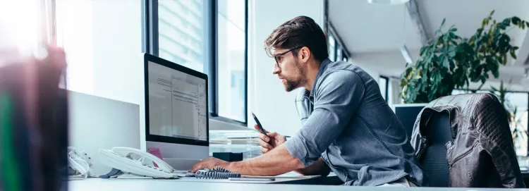 Person on their desk looking at laptop