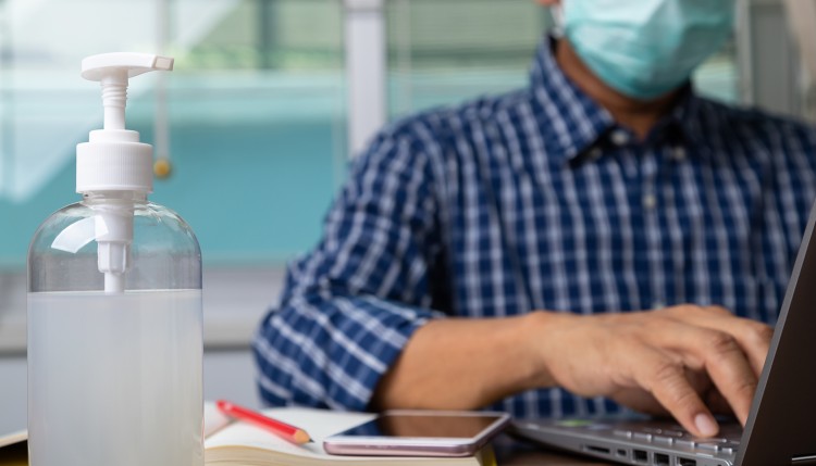 Laptop user wearing a mask.