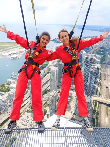 Shivani Aggarwal braves the CN Tower EdgeWalk with CIBC mentor-buddy, Meaghan Moore.